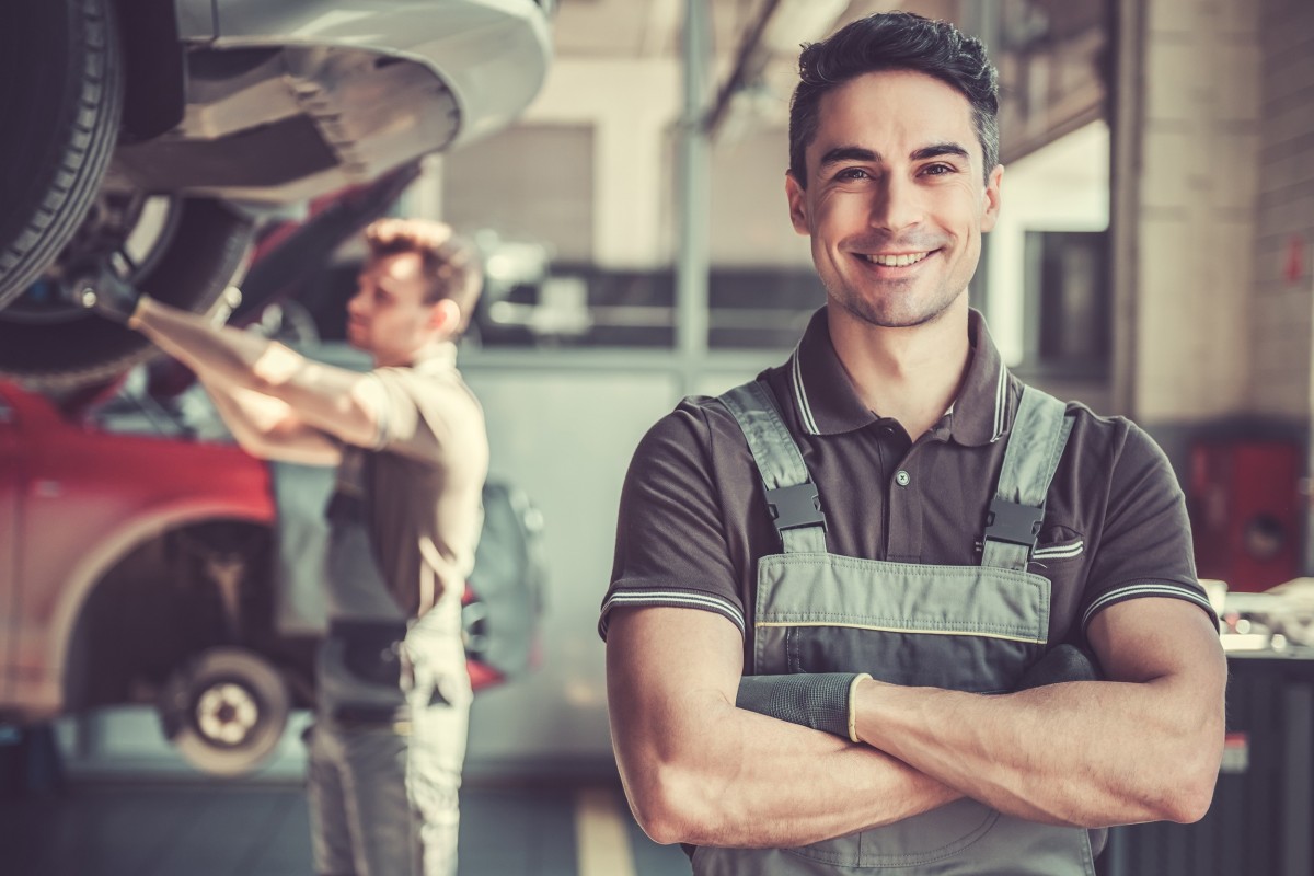 mechanic holding tool in shop bay